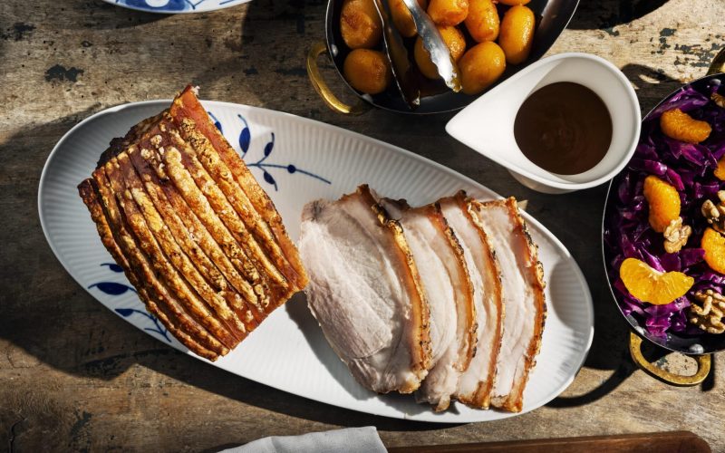 A joint of pork or Flaeskesteg carved into slices. This is a very traditional dish from Denmark. The skin of the pork is cut, salt is rubbed into it, and dried bay leaves and cloves are inserted into the cuts to give the cooked meat a distinctive taste and smell. Colour, horizontal format view with some copy space.