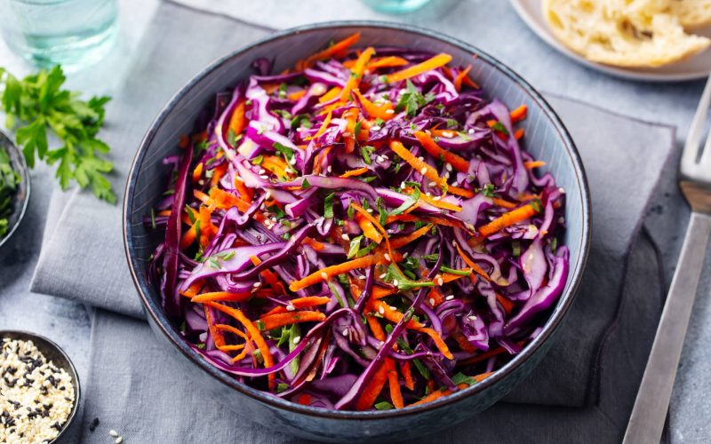Red cabbage salad. Coleslaw in a bowl. Grey background. Close up
